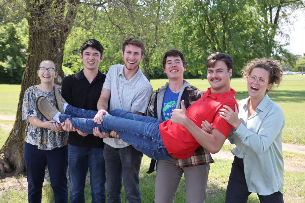 Interns outdoors holding Luke